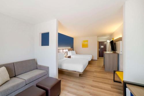une chambre d'hôtel avec un lit et un canapé dans l'établissement Comfort Inn Asheville Airport, à Fletcher