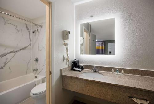 a bathroom with a sink and a mirror and a toilet at Quality Inn Tallahassee near University in Tallahassee