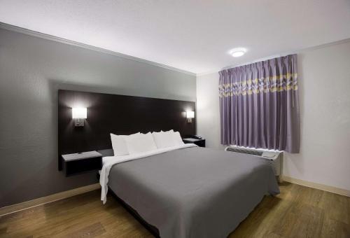 Un dormitorio con una gran cama blanca y una ventana en Quality Inn Tallahassee near University, en Tallahassee