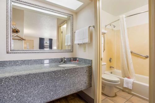 a bathroom with a sink and a toilet and a mirror at Econo Lodge Lebanon in Lebanon