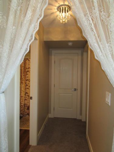 a hallway with curtains and a door with a chandelier at Okanagan Lake Sunrise BB in Vernon