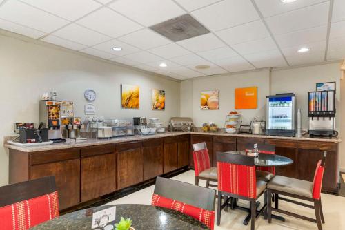 a restaurant with a counter and tables and chairs at Comfort Inn Alpharetta-Atlanta North in Alpharetta