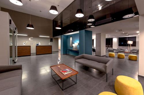 a lobby with couches and chairs and a table at Comfort Inn Delicias in Delicias