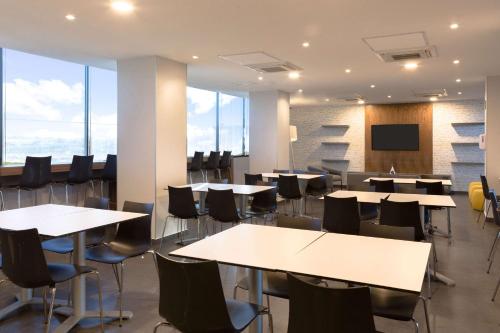 a conference room with tables and chairs and a tv at Comfort Inn Delicias in Delicias