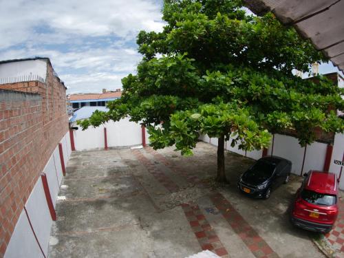 a car parked in a parking lot next to a tree at Hotel Los Balcones in Tocaima
