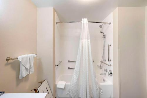 bagno bianco con doccia e vasca di Sleep Inn North - Central York a York