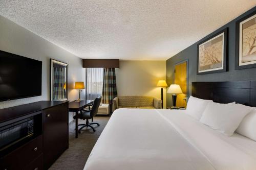 a hotel room with a large bed and a desk at Suburban Studios in San Angelo