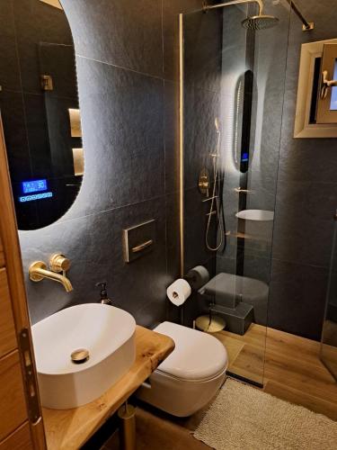a bathroom with a toilet and a sink and a shower at Villagio inn Suite & Spa in Soúlion
