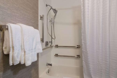 a bathroom with a shower and white towels at The Inn on Maritime Bay, Ascend Hotel Collection in Manitowoc