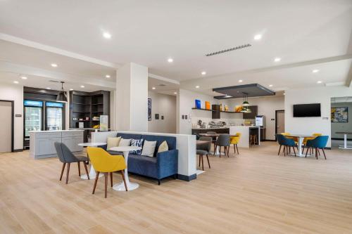 a lobby with a blue couch and tables and chairs at Comfort Inn & Suites New Port Richey Downtown District in New Port Richey