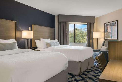 a hotel room with two beds and a window at The Inn on Maritime Bay, Ascend Hotel Collection in Manitowoc