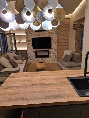 a kitchen with a living room with a fireplace at Villagio inn Suite & Spa in Soúlion