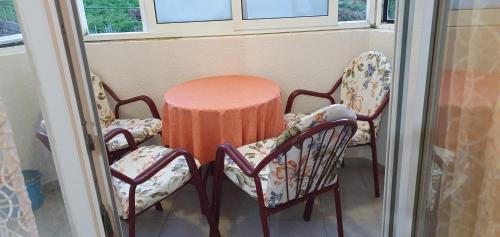 2 sillas y una mesa en una habitación con ventanas en Studio Budva, en Budva