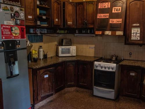 uma cozinha com armários de madeira, um fogão e micro-ondas em DCH Hostel Backpaquers em Concordia