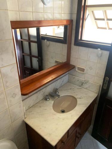 a bathroom with a sink and a mirror at POUSADA BELLA SPIAGGIA in Paraty