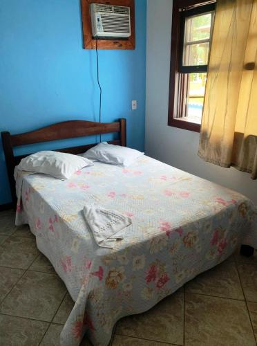 a bed in a blue bedroom with a window at POUSADA BELLA SPIAGGIA in Paraty