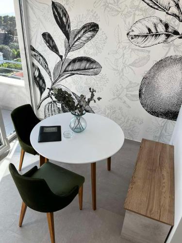 a white table with two chairs and a vase on it at MEMORI bed&breakfast in Rab