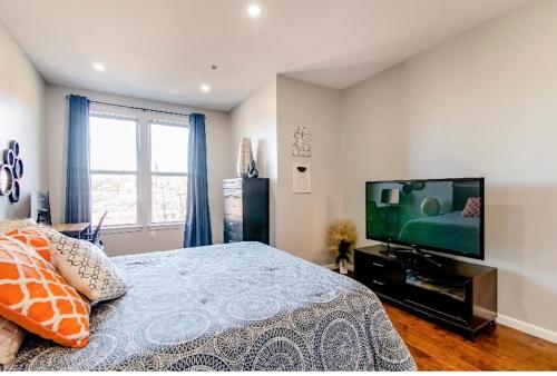a bedroom with a bed and a flat screen tv at Downtown Shared Apartment in Providence