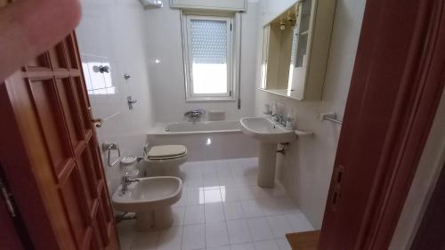 bagno con 2 servizi igienici, lavandino e specchio di Lemon Gold a Locogrande