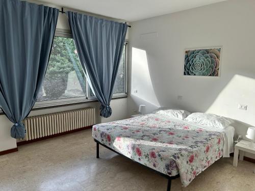 a bedroom with a bed and a large window at Casa Domus del Chirurgo in Rimini