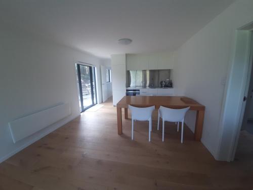 a kitchen and dining room with a table and chairs at Ariki beachfront apartment in Snells Beach