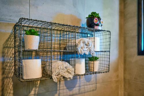 a wire shelf with potted plants on a wall at La Niche by the Beach in Ocean Shores