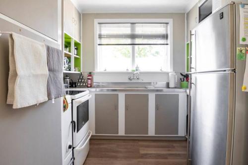 a kitchen with a sink and a refrigerator at Turangi Home Family Size in Taupo