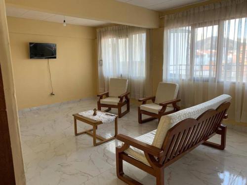 a living room with three chairs and a tv at Ultimo piso c/ terraza centrico in Cochabamba