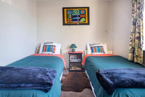 een slaapkamer met 2 bedden en een foto aan de muur bij Turangi Home Family Size in Taupo