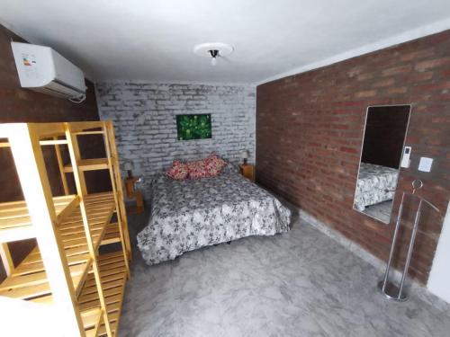 a bedroom with a bed and a brick wall at Parada Haus - Departamento en centro de San Juan in San Juan