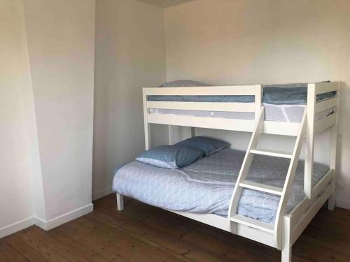 a white bunk bed with a ladder next to a bedroom at La briqueterie de Maromme in Maromme