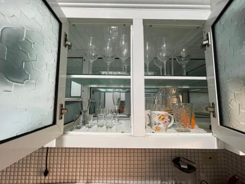 a cabinet filled with wine glasses in a kitchen at Oasis de paz 2 in Jarabacoa