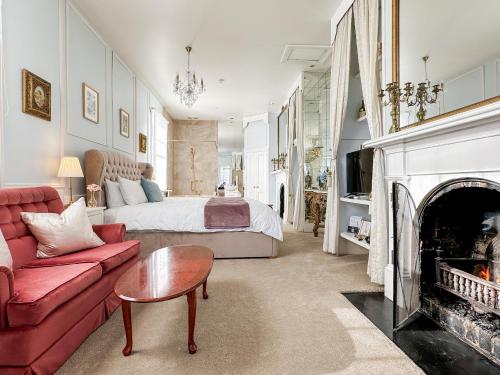 uma sala de estar com um sofá vermelho e uma cama em Alice's Cottages em Launceston