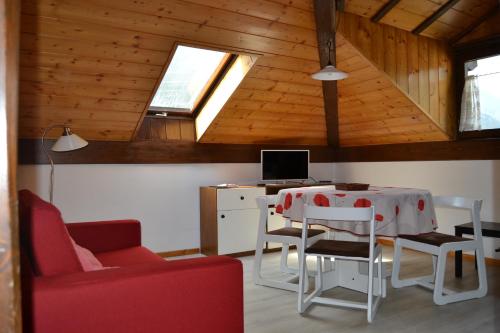 a room with a table and chairs and a computer at Dimaro Folgarida Appartamento trilocale in villa in Monclassico