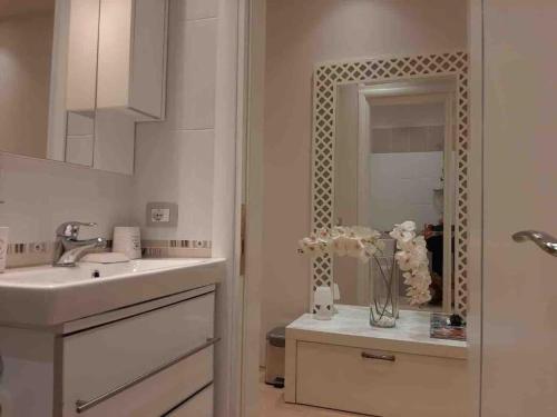 a white bathroom with a sink and a mirror at Sea View Apartment with Veranda Beach Amazing in Vlorë