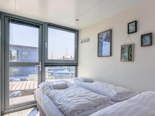 2 Betten in einem Zimmer mit Fenster in der Unterkunft Tiny houseboat Uitgeest I in Uitgeest