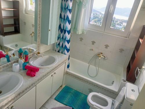 a bathroom with two sinks and a shower and a toilet at Τάνια in Anavissos