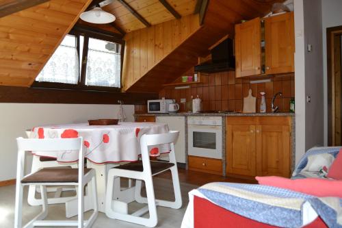 a kitchen with a table and chairs in a room at Dimaro Folgarida Appartamento trilocale in villa in Monclassico