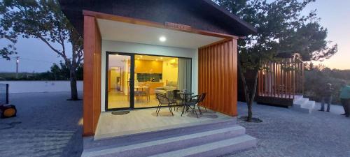a small house with a porch with a table and chairs at School Motorhome Park in Óvoa