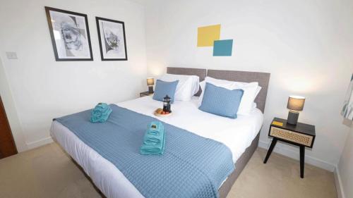 Quayside Apartments في دندي: غرفة نوم بسريرين مع وسائد زرقاء
