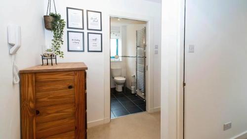 a hallway with a bathroom with a toilet and a mirror at Quayside Apartments in Dundee