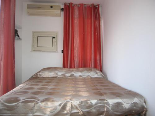 a bed in a room with red curtains at La Terrazza di Apollo al centro di Ortigia in Siracusa