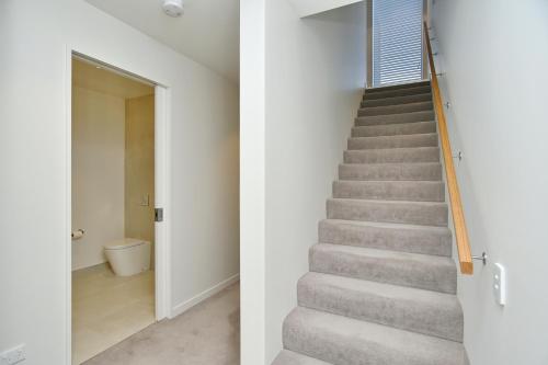 un escalier menant au deuxième étage d'une maison dans l'établissement Worcester Terrace One - Christchurch Holiday Homes, à Christchurch
