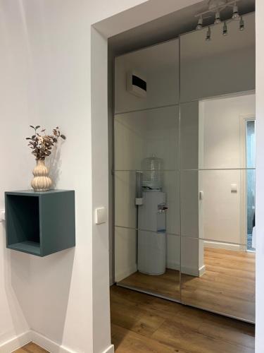 a glass wall in a room with a refrigerator at Boutique Serenity in Cluj-Napoca