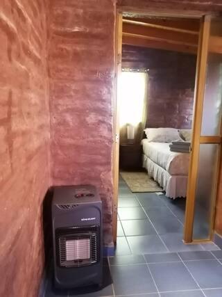 a room with a heater in the corner of a bedroom at Hostal Solor in San Pedro de Atacama