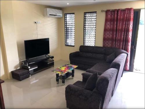 a living room with couches and a flat screen tv at Stunning Two-Bedroom: Perfect Home Away from Home in Suva