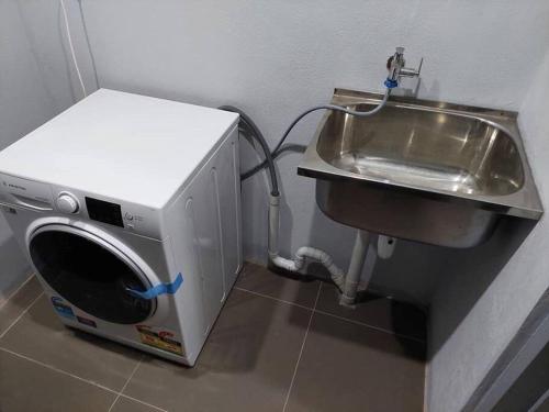 a washing machine next to a sink in a bathroom at Stunning Two-Bedroom: Perfect Home Away from Home in Suva