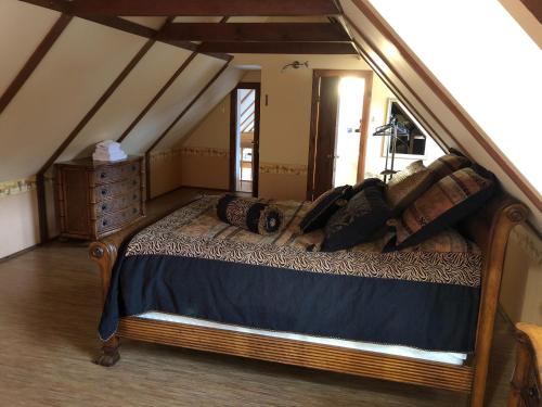 a bedroom with a large bed in a attic at Kid's House in Padure
