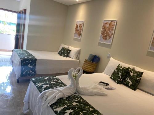 um quarto com duas camas com um cisne em Santorini Beach Hotel em Arraial d'Ajuda