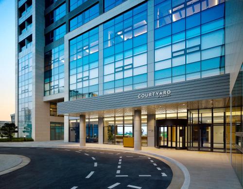 a large glass building with a street in front of it at Courtyard by Marriott Sejong in Sejong